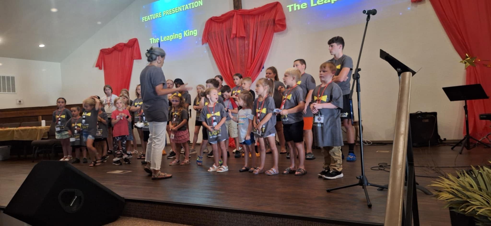 Children and adult helpers gathered at the front of the church sanctuary